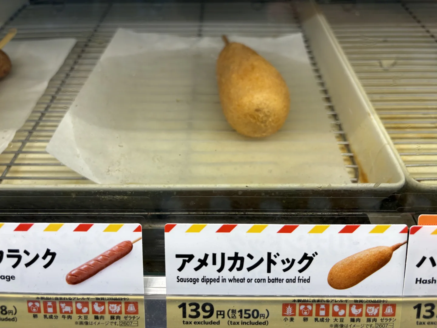 American Dog in the hot-food case above its matching 150 yen tax-inclusive sign