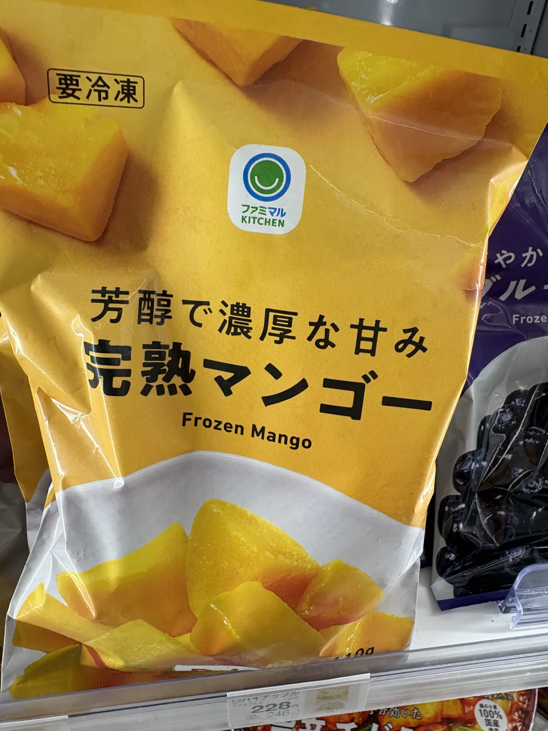 Yellow bag of frozen ripe mango above a shelf ticket for a different fruit product